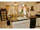 Cozy kitchen with dishwasher, white cabinetry, and adjacent dining area filled with natural light at 8735 Sw 192Nd Court Rd, Dunnellon, FL 34432