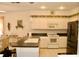 Bright kitchen featuring black countertops, white cabinetry, and stainless steel appliances at 8735 Sw 192Nd Court Rd, Dunnellon, FL 34432