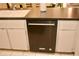 A kitchen featuring a stainless steel KitchenAid dishwasher, a white sink, and tile flooring at 8735 Sw 192Nd Court Rd, Dunnellon, FL 34432