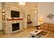 Inviting living room showcasing a stone fireplace, a large television, and a comfortable couch at 8735 Sw 192Nd Court Rd, Dunnellon, FL 34432