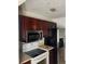 Kitchen includes wood cabinets, stainless steel refrigerator and microwave, and white range at 922 Se 13Th St, Ocala, FL 34471