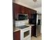 Kitchen with wood cabinets, stainless steel refrigerator and microwave, and white range at 922 Se 13Th St, Ocala, FL 34471
