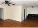 Spacious living room with hardwood floors, featuring a dark leather sofa and simple lighting fixtures at 922 Se 13Th St, Ocala, FL 34471
