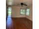 Bright living room features hardwood flooring, a ceiling fan, and natural light through the windows at 922 Se 13Th St, Ocala, FL 34471