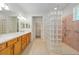 Bathroom with double sink vanity, glass block shower, and tile flooring at 9511 Sw 71St Loop, Ocala, FL 34481