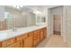 Bathroom with double sink vanity, glass block shower, walk-in closet, and tile flooring at 9511 Sw 71St Loop, Ocala, FL 34481
