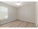 Bright bedroom features light wood-look flooring, a ceiling fan, and a large window at 9511 Sw 71St Loop, Ocala, FL 34481