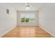 Bedroom with wood floors, ceiling fan, and a large window with a view to the lake at 9511 Sw 71St Loop, Ocala, FL 34481