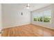 Bedroom with wood floors, ceiling fan, and a large window with a view to the outdoors at 9511 Sw 71St Loop, Ocala, FL 34481