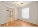 Bright bedroom with wood floors featuring a doorway with view to living area, and a window with blinds at 9511 Sw 71St Loop, Ocala, FL 34481
