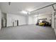 Spacious garage featuring gray carpet, storage, and a golf cart at 9511 Sw 71St Loop, Ocala, FL 34481