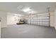 Spacious garage with golf cart, dual garage doors, high ceilings and carpeted floor at 9511 Sw 71St Loop, Ocala, FL 34481