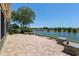 Paver patio has stone accents and overlooks a lake for a relaxing backyard view at 9511 Sw 71St Loop, Ocala, FL 34481