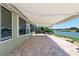 Covered patio with stone pavers overlooking a beautiful lake and greenery at 9511 Sw 71St Loop, Ocala, FL 34481