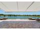 A large patio with brick pavers overlooks the serene lake and surrounding landscape at 9511 Sw 71St Loop, Ocala, FL 34481