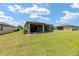 Well-maintained backyard featuring a lush green lawn, mature trees, and a screened-in patio for outdoor enjoyment at 9658 Sw 76Th Lane Rd, Ocala, FL 34481