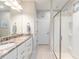 Elegant bathroom featuring double sinks, granite countertops, and a glass-enclosed shower at 9658 Sw 76Th Lane Rd, Ocala, FL 34481