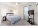Cozy bedroom featuring a queen-sized bed, ceiling fan, and a mounted television near a bright window at 9658 Sw 76Th Lane Rd, Ocala, FL 34481