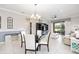 Dining room with modern chandelier, glass table, stylish chairs, and view of outdoor patio at 9658 Sw 76Th Lane Rd, Ocala, FL 34481