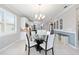 Elegant dining area featuring a modern chandelier and ample natural light from large windows at 9658 Sw 76Th Lane Rd, Ocala, FL 34481