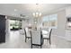 Bright living room with sliding glass doors to screened lanai and dining area with chandelier at 9658 Sw 76Th Lane Rd, Ocala, FL 34481