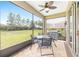 Relaxing screened-in patio with outdoor dining and grilling areas, overlooking a spacious backyard and trees at 9658 Sw 76Th Lane Rd, Ocala, FL 34481