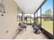 Inviting covered patio with comfortable wicker seating and a tranquil view of the well-maintained yard at 9658 Sw 76Th Lane Rd, Ocala, FL 34481