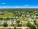 This aerial view showcases a serene neighborhood surrounded by mature trees and beautiful green spaces under a clear sky at 10016 Sw 62Nd Cir, Ocala, FL 34476