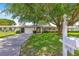 Single-story home with attached garage, well-maintained landscaping, a large tree and a manicured lawn creating an inviting exterior at 10016 Sw 62Nd Cir, Ocala, FL 34476