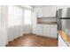 Bright kitchen featuring white cabinets, granite countertops, and stainless steel refrigerator at 10016 Sw 62Nd Cir, Ocala, FL 34476