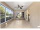 Bright sunroom with tile floor, ceiling fan, and screened windows at 10016 Sw 62Nd Cir, Ocala, FL 34476
