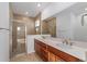 Bathroom features double sinks, wood cabinets and a glass enclosed shower at 10277 Sw 96Th Loop, Ocala, FL 34481