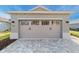 Two car garage door on a single-Gathering home with a brick driveway at 10277 Sw 96Th Loop, Ocala, FL 34481