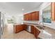 Open kitchen with stainless steel appliances, granite countertops, wood cabinets, and tile floors at 10277 Sw 96Th Loop, Ocala, FL 34481