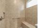 Shower area has tiled walls, a seat, and a grab bar for accessibility at 10277 Sw 96Th Loop, Ocala, FL 34481