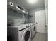 Efficient laundry room with a washer, dryer, and shelving for storage at 1100 Nw 126Th Ln, Citra, FL 32113