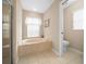 Bathroom with a jetted tub, tile flooring, a separate toilet area, and a window at 11147 Sw 53Rd Cir, Ocala, FL 34476
