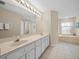 Bathroom featuring double sinks, vanity with ample storage, and a separate soaking tub at 11147 Sw 53Rd Cir, Ocala, FL 34476