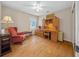 Bedroom with hardwood floors, desk, ceiling fan, and a red chair with bench seating at 11147 Sw 53Rd Cir, Ocala, FL 34476