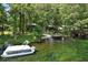 Aerial view of a waterfront property with a boat dock, a boat, a sandy beach, and lush trees at 11170 Sw 190Th Ave, Dunnellon, FL 34432