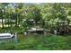 Aerial view of a waterfront property with a boat dock, a boat, a sandy beach, and lush trees at 11170 Sw 190Th Ave, Dunnellon, FL 34432