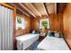 Charming bedroom with twin beds, wood-paneled walls, and bright windows for natural light at 11170 Sw 190Th Ave, Dunnellon, FL 34432