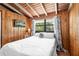 Comfortable bedroom featuring natural wood walls, cozy bedding, and soft, natural lighting at 11170 Sw 190Th Ave, Dunnellon, FL 34432
