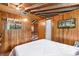 Bedroom with wood-paneled walls, featuring a comfortable bed and natural light at 11170 Sw 190Th Ave, Dunnellon, FL 34432