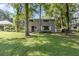 Two-story home exterior with gray siding, white trim, and a large yard with mature trees offering ample shade at 11170 Sw 190Th Ave, Dunnellon, FL 34432