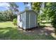Outdoor storage shed with siding, a window box with flowers, and a matching door, set in a well-maintained yard at 11170 Sw 190Th Ave, Dunnellon, FL 34432