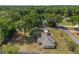 Birds-eye view of a home featuring solar panels, a metal roof, and large backyard with mature trees in a wooded neighborhood at 1601 Ne 47Th Ct, Ocala, FL 34470