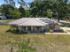Aerial view of a single-story house with metal roof, solar panels, and a well-manicured lawn at 1601 Ne 47Th Ct, Ocala, FL 34470