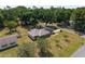 Aerial view of a home with solar panels, a metal roof, a large yard, and mature trees in a wooded neighborhood at 1601 Ne 47Th Ct, Ocala, FL 34470