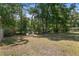 Secluded backyard seating area surrounded by mature trees and lush landscaping at 1601 Ne 47Th Ct, Ocala, FL 34470